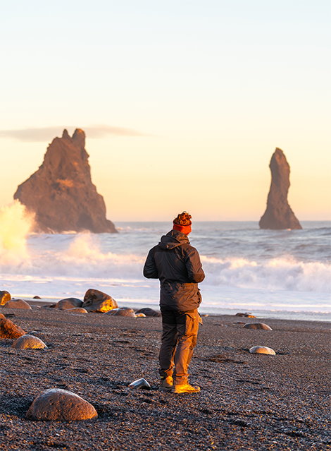 Man standing at shore looking at car